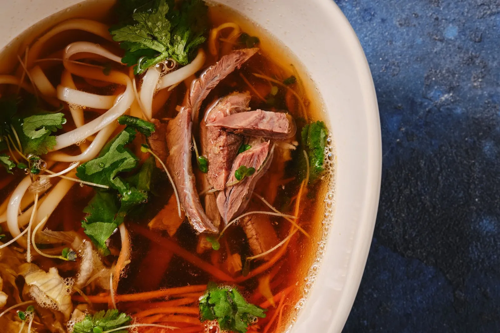Bát miến ngan nóng hổi với thịt ngan thái mỏng, măng chua và rau thơm rắc đều trên cùng