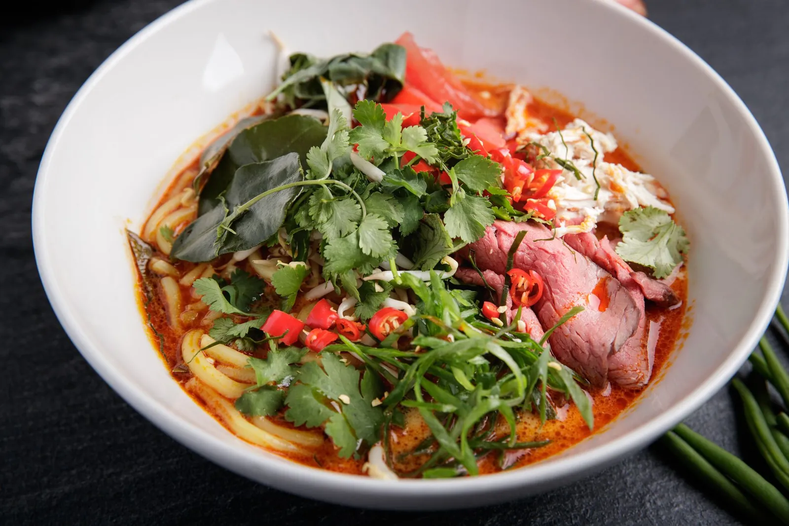 Tô bún cù kỳ với những mảng thịt cua cù kỳ đỏ au, nước dùng trong vắt điểm xuyết hành lá xanh mướt
