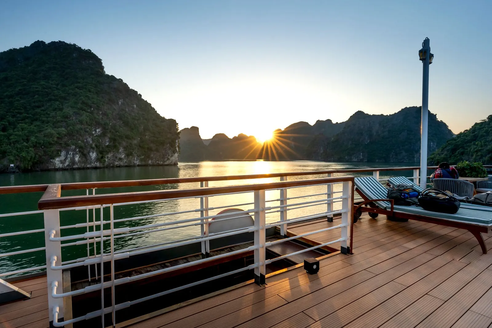 Nhóm bạn trẻ check-in trên boong tàu du ngoạn Vịnh Hạ Long buổi chiều tà